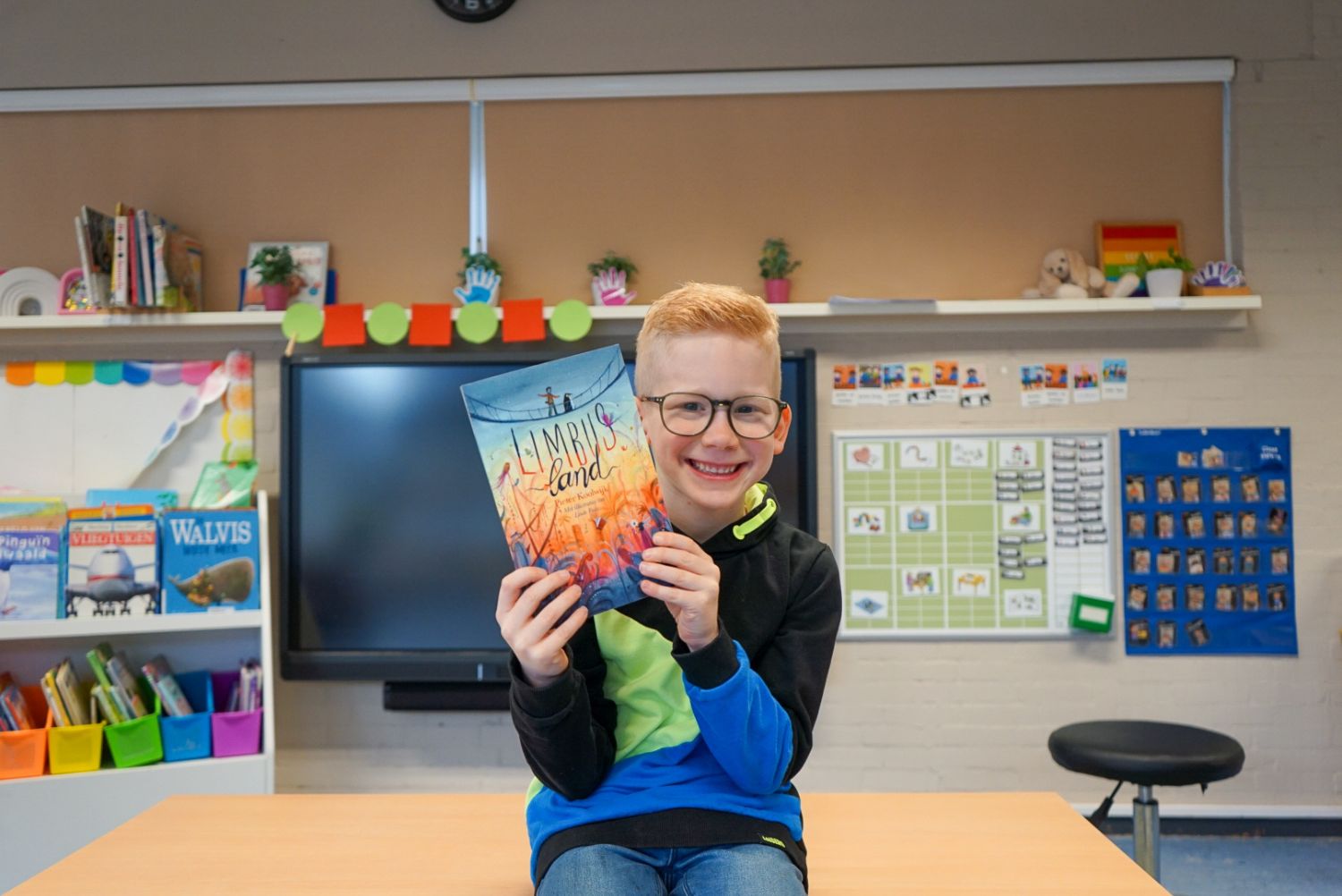 Kind van BSO KwestKids Kompas houd boek cadeau vast